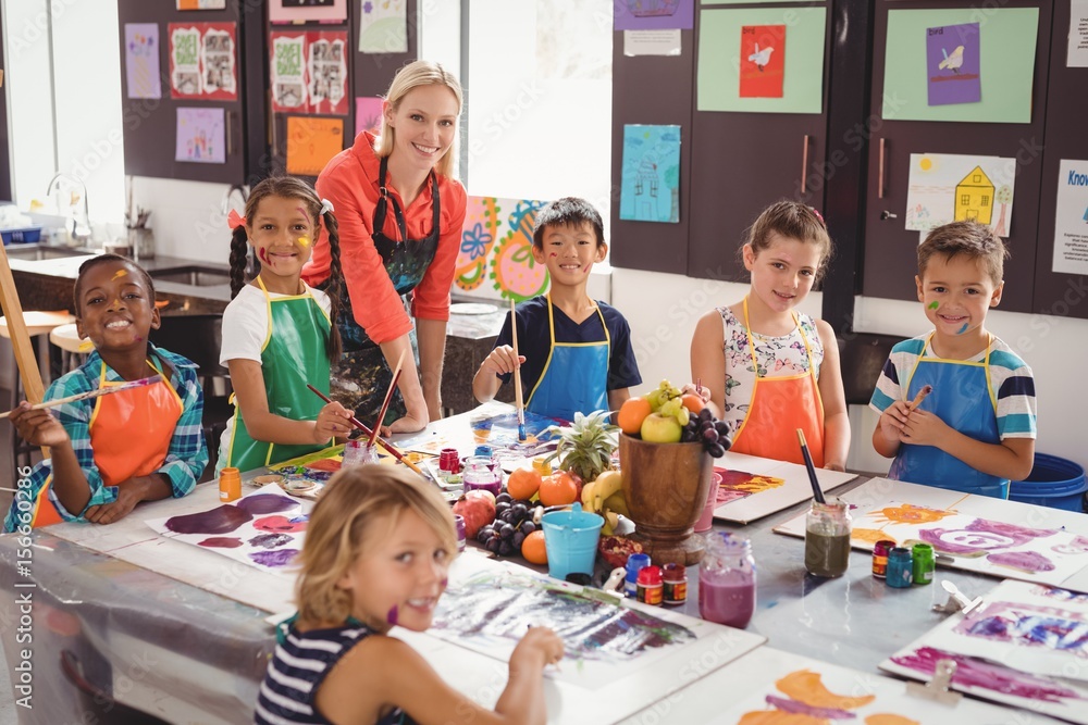 Obraz premium Portrait of smiling teacher and schoolkids