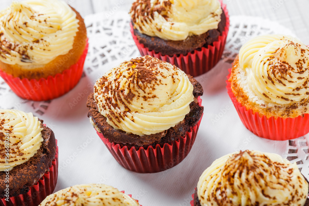 Tasty cupcakes with candies and chocolate on light background close up Tasty cupcakes with candies and chocolate on light background close up