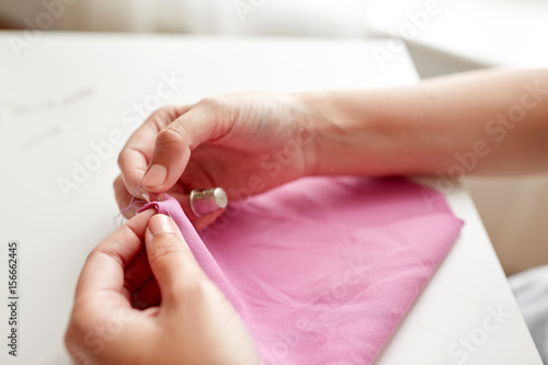 woman with needle stitching fabric pieces