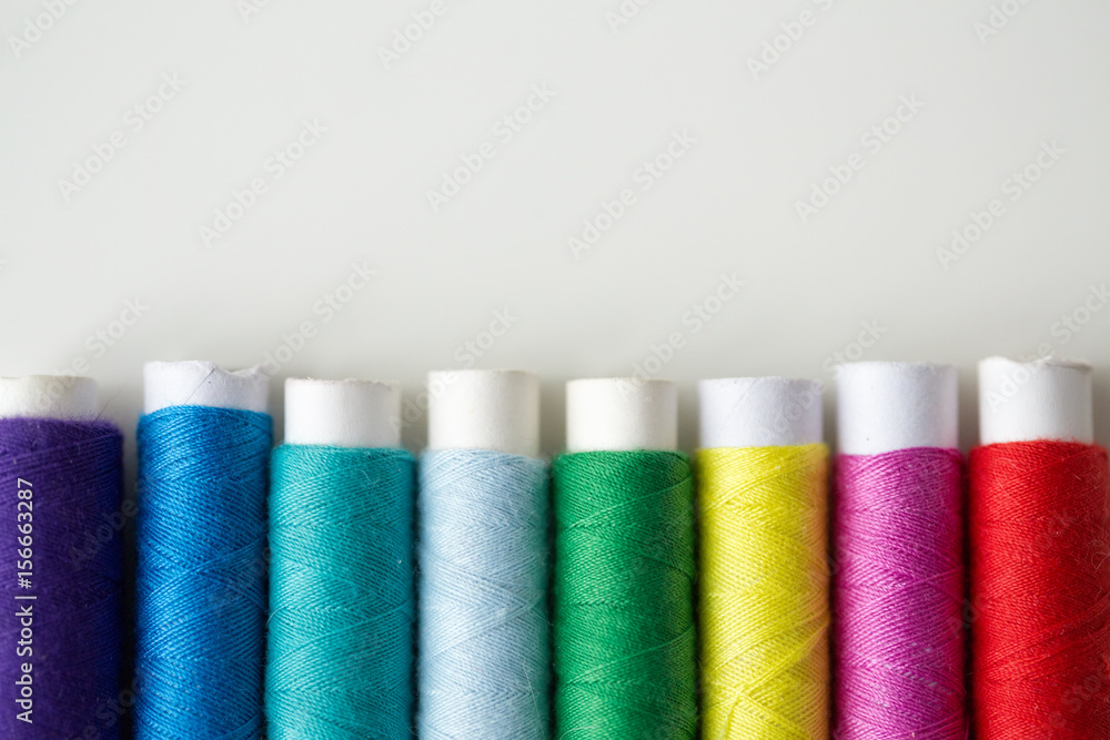 row of colorful thread spools on table row of colorful thread spools on table