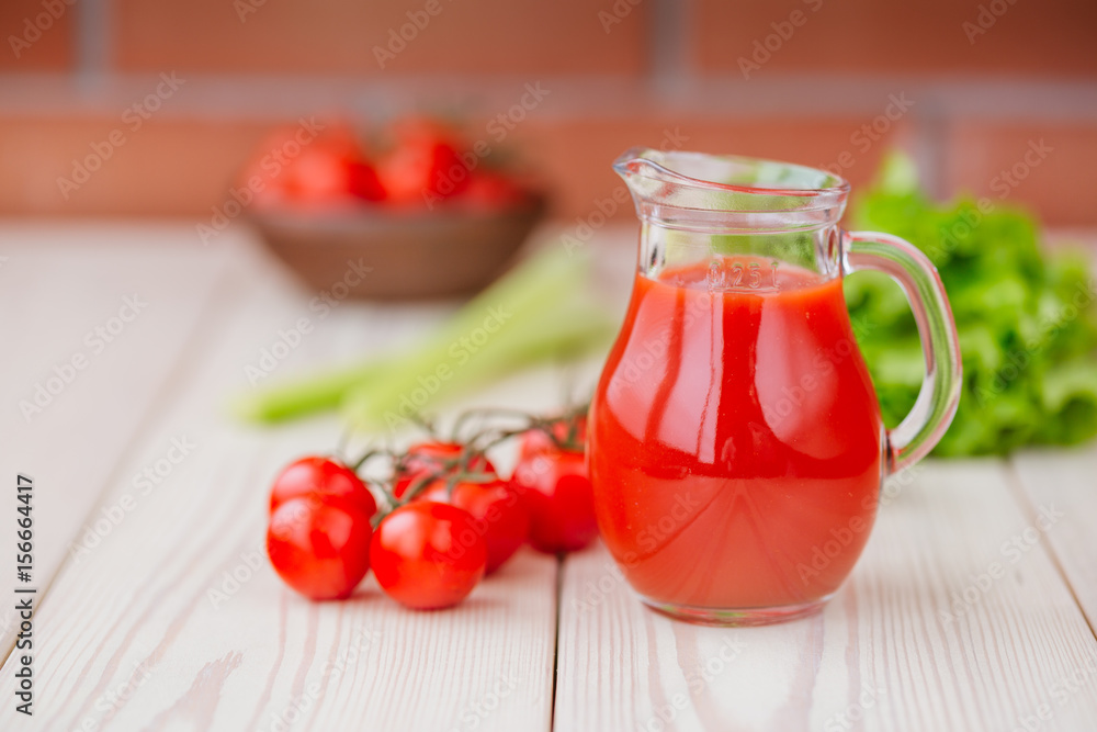 Tomato juice in a glass jar on a wooden table. Love for a healthy raw food concept. Tomato juice in a glass jar on a wooden table. Love for a healthy raw food concept.