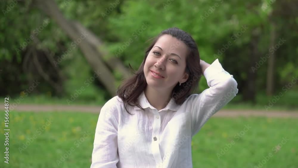 Beautiful playful woman sitting and swinging on a swing in summer Park, straightens hair, smiling and looking at camera. Slow motion HD 1920x1080 Beautiful playful woman sitting and swinging on a swing in summer Park, straightens hair, smiling and looking at camera. Slow motion HD 1920x1080