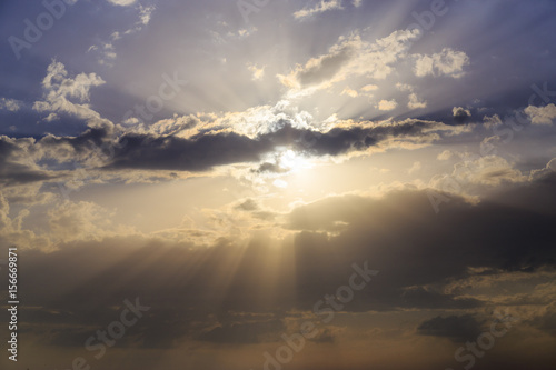 Empty cloudy sky from orange to blue with sun rays during the sunset © Solidasrock