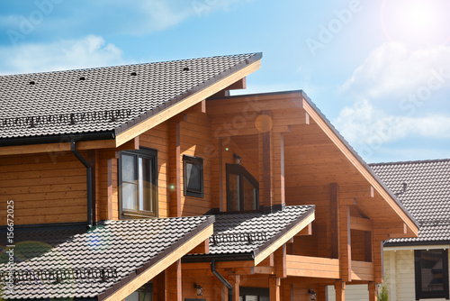 Facade of a beautiful wooden house and sun beams