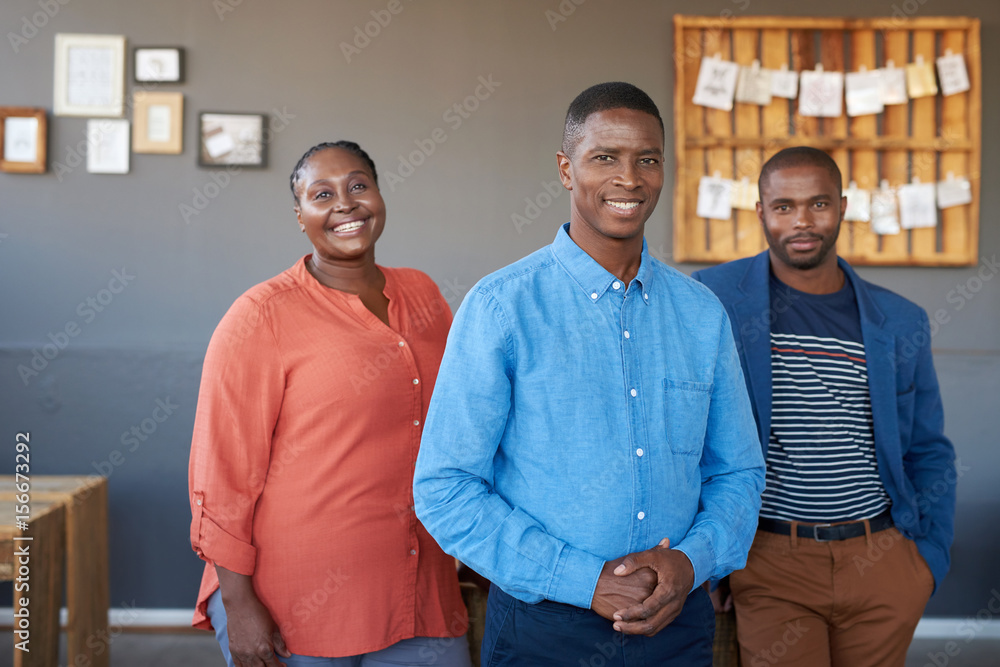 Smiling African business colleagues standing together in a modern ...