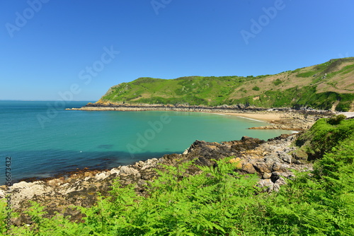 Giffard Bay, Jersey, U.K. Wide angle image of a picturesque beach with a teal sea.