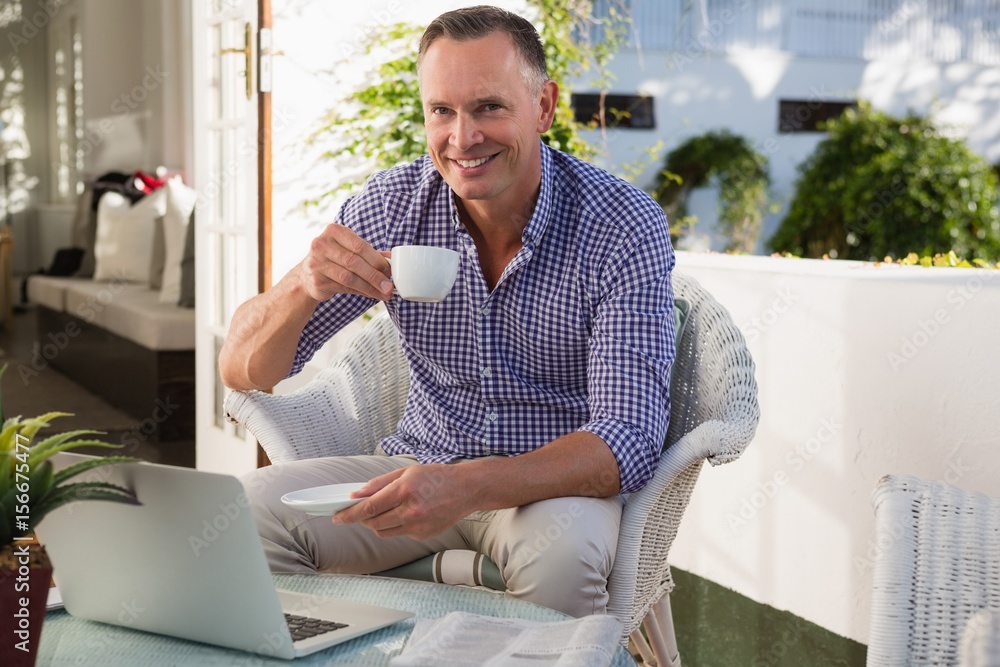 Man drinking coffee while sitting by laptop Man drinking coffee while sitting by laptop