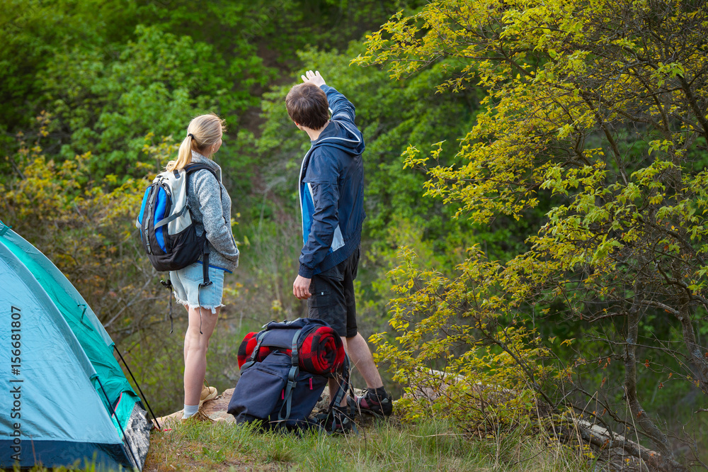 Fototapeta premium A couple take a break while backpacking on a prepared trail