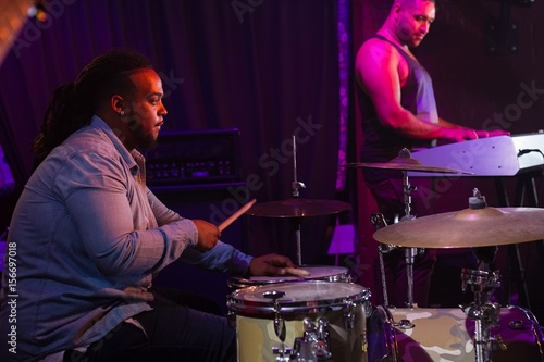 Drummer playing on drum set on stage photo