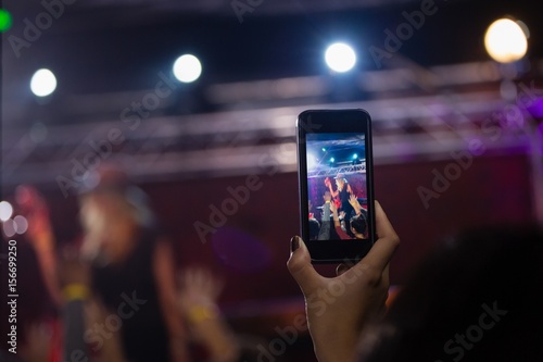 Audience recording video of band on mobile phone