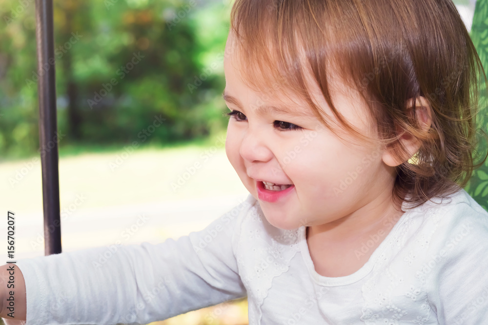 Happy toddler girl swinging on a swing Happy toddler girl swinging on a swing
