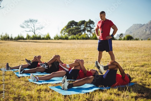 Trainer instructing kids while exercising in the boot camp