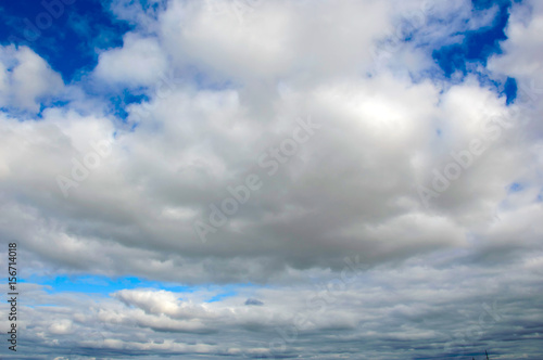 Panorama of the cloudy sky. Background with large white clouds in the atmosphere. The idyllic landscape of the firmament.