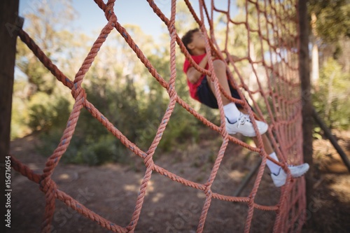 Determined boy climbing a net during obstacle course