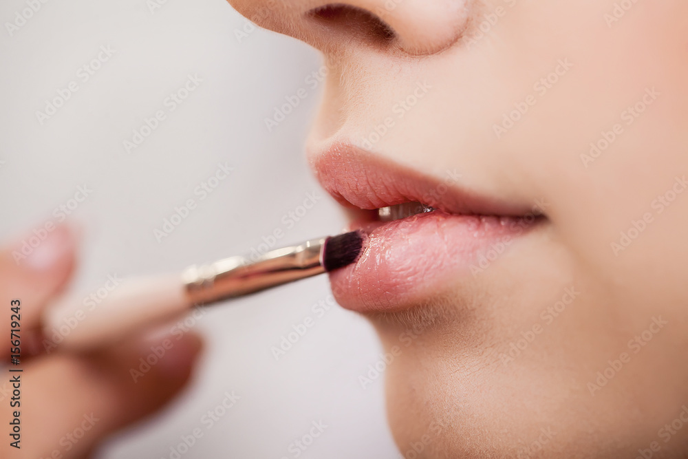 Make-up artist does makeup to a beautiful girl in a beauty salon