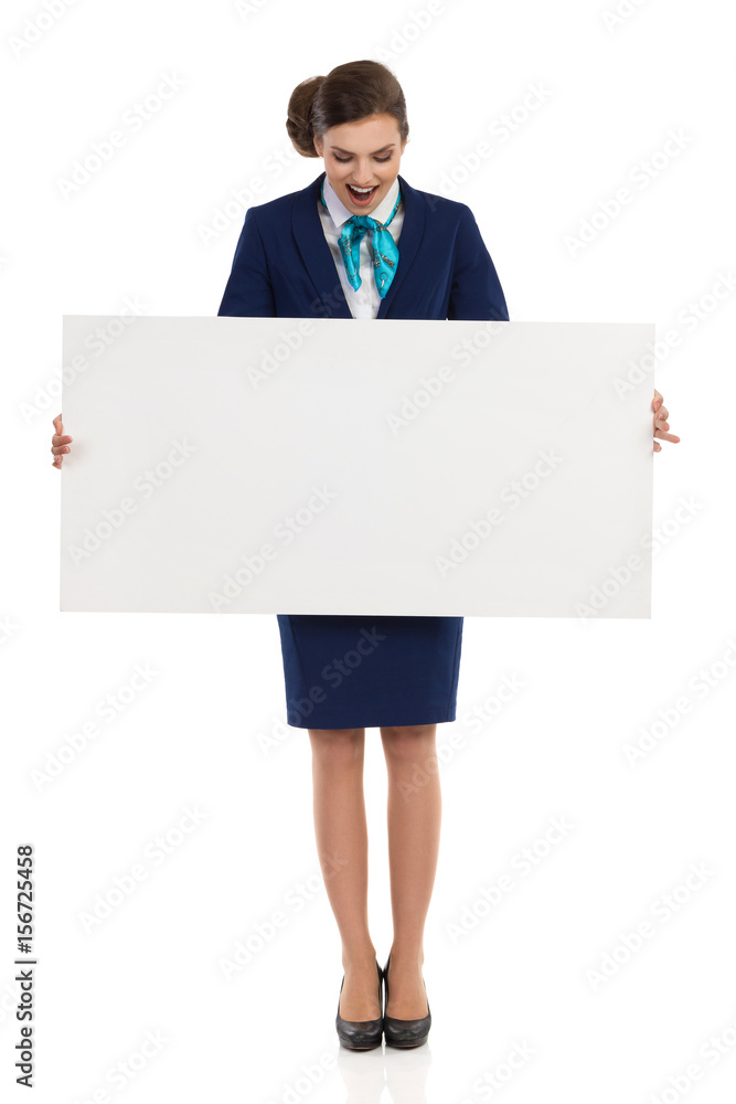 Surprised Stewardess Is Holding White Poster And Reading Surprised Stewardess Is Holding White Poster And Reading