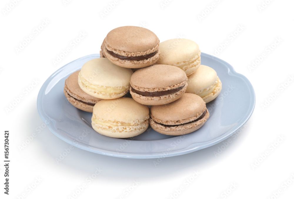 Chocolate and Vanilla Macarons on Blue Plate with White Background Chocolate and Vanilla Macarons on Blue Plate with White Background