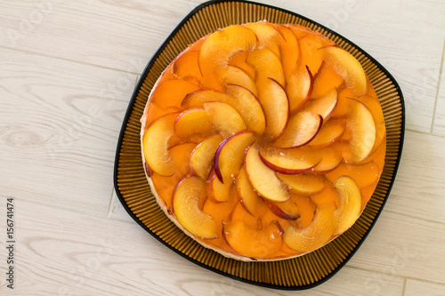 Wallpaper Mural Fruit cake with peach, jelly and mousse in plate on wooden background. Aerial view. Torontodigital.ca