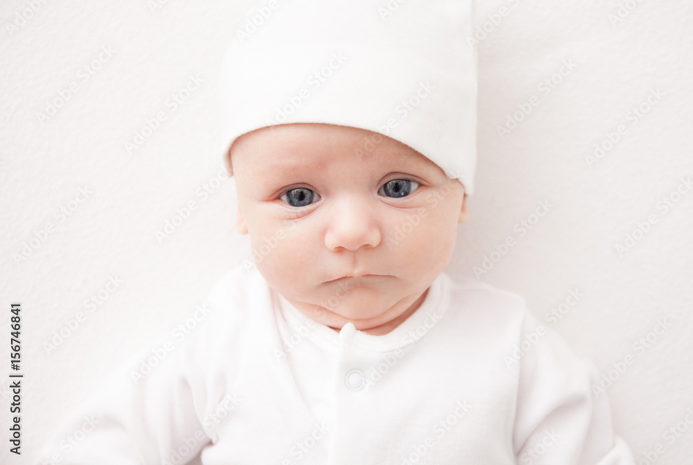 Cute adorable newborn baby girl in white bed and looking at the camera Cute adorable newborn baby girl in white bed and looking at the camera