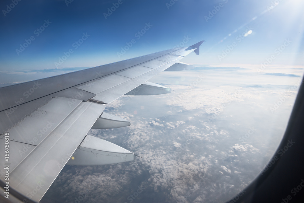 Wing of an airplane flying above the clouds