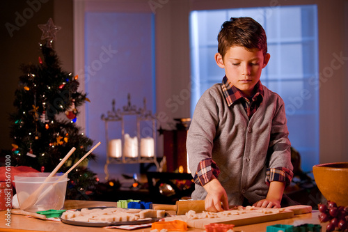 Little boy baking Christmas cookies at home.