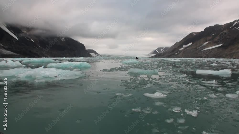 Moving Ice Floes on background of mountain on water of Arctic Ocean in Svalbard. Wildlife in Nordic badlands. Unique footage on background natural landscape and snow of Spitsbergen. Moving Ice Floes on background of mountain on water of Arctic Ocean in Svalbard. Wildlife in Nordic badlands. Unique footage on background natural landscape and snow of Spitsbergen.