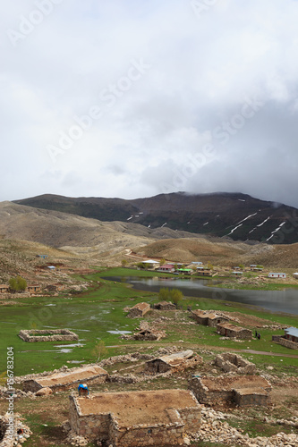 Mountain landscape with sloped covered by melting snow and villa photo