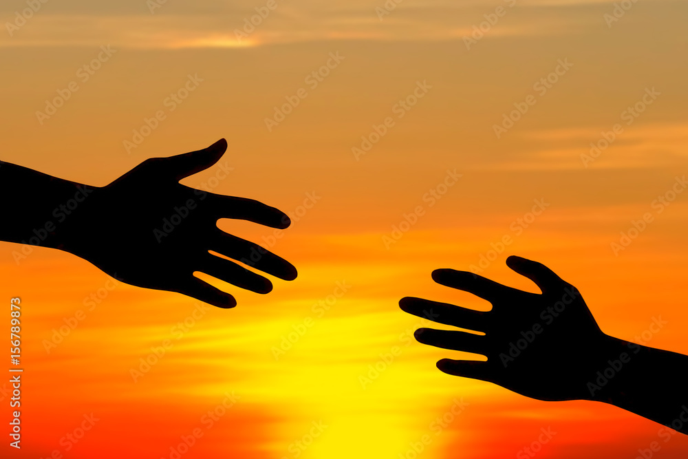 silhouette of helping hand concept at sunset.