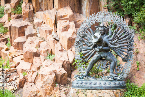 Tantric Deities statue in Ritual Embrace located in a mountain garden