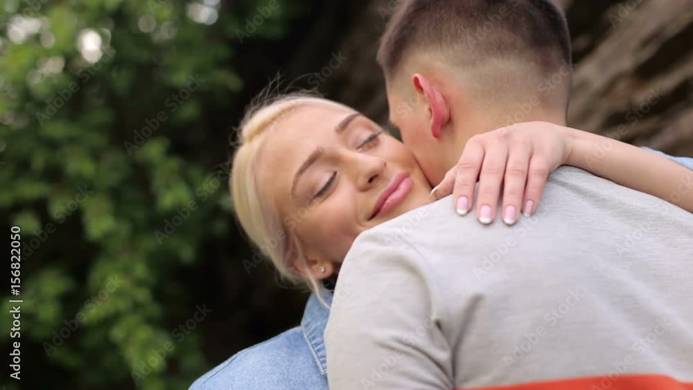 Beautiful girl hugs and kisses her boyfriend outdoors in the Park. Close-up. Portrait of a girl in love hugging her boyfriend. Beautiful girl hugs and kisses her boyfriend outdoors in the Park. Close-up. Portrait of a girl in love hugging her boyfriend.