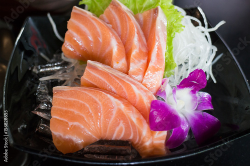 Sliced Salmon Sashimi Served On Black Plate