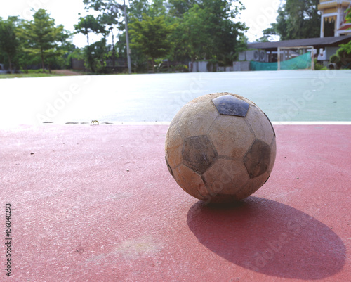 Old futsal ball on red field, old futsal ball is placed on red field 