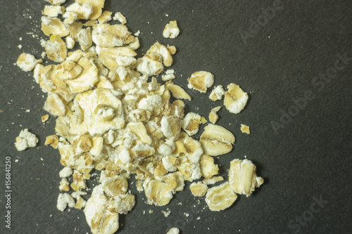 Macro of white oatmeal isolated on dark background © LuXpics