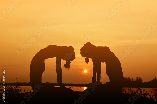 Silhouette women yoga in nature ,color of vintage tone