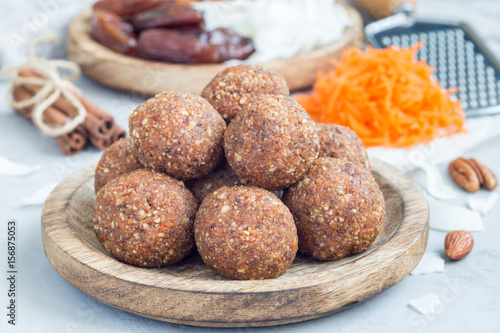 Healthy homemade paleo energy balls with carrot, nuts, dates and coconut flakes, on wooden plate, horizontal © iuliia_n