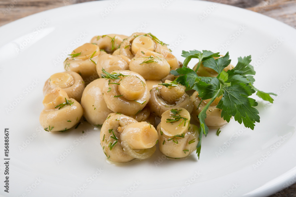 Canned mushrooms on a white plate Canned mushrooms on a white plate