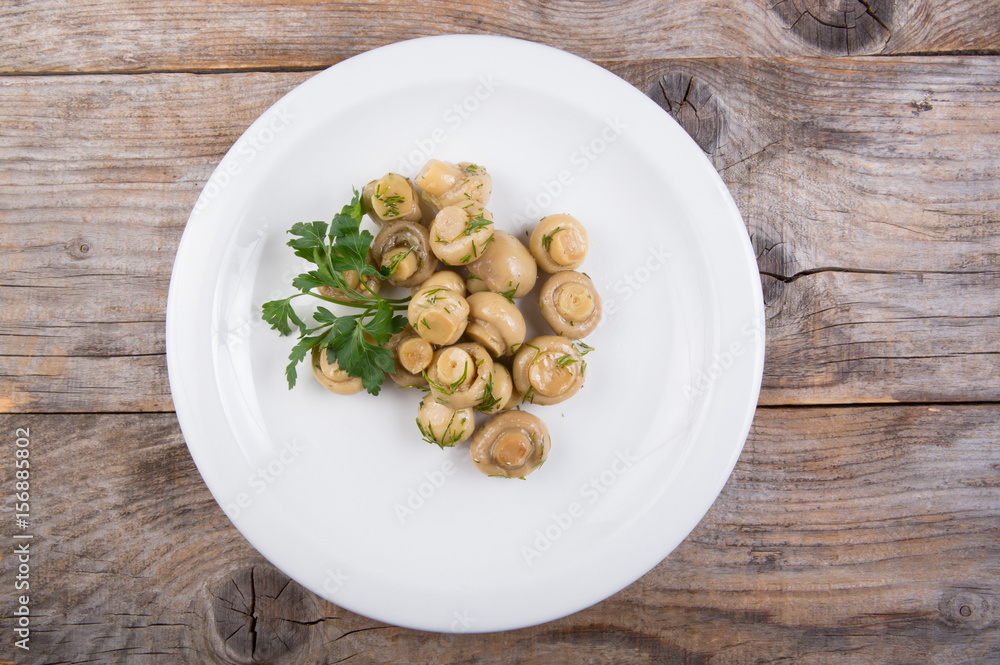 Canned mushrooms on a white plate Canned mushrooms on a white plate