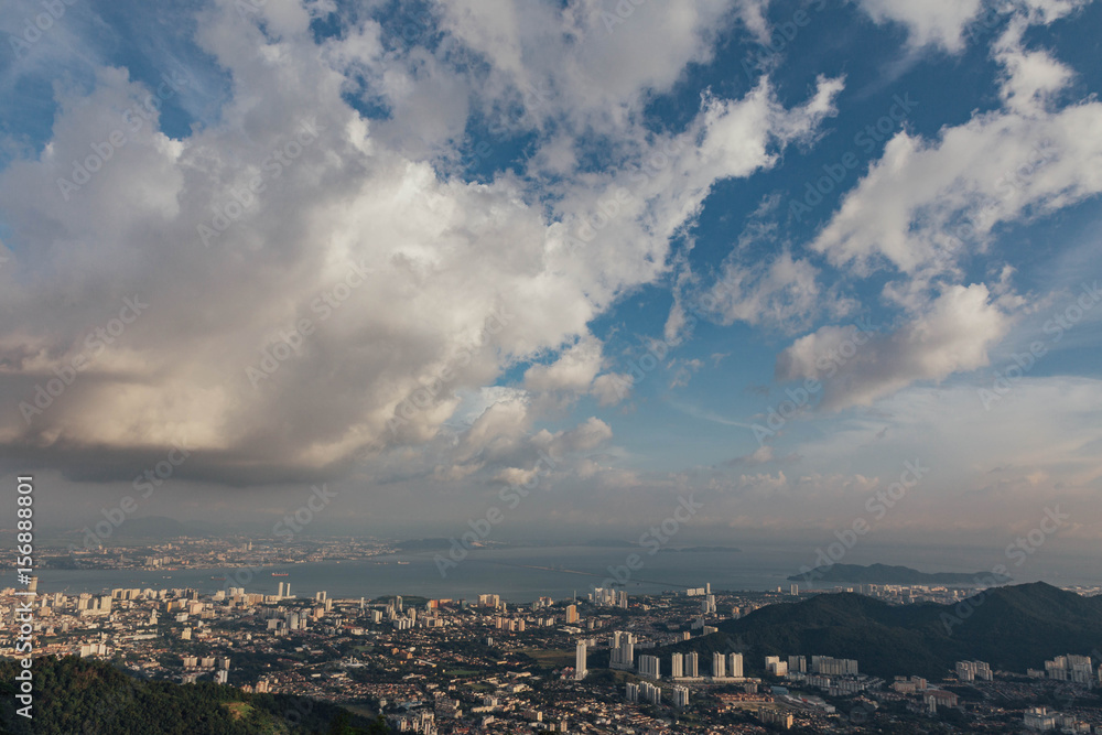 Cloudy sky, cityscape and mountain with green that viewed from Penang Hill at George Town. Penang, Malaysia.