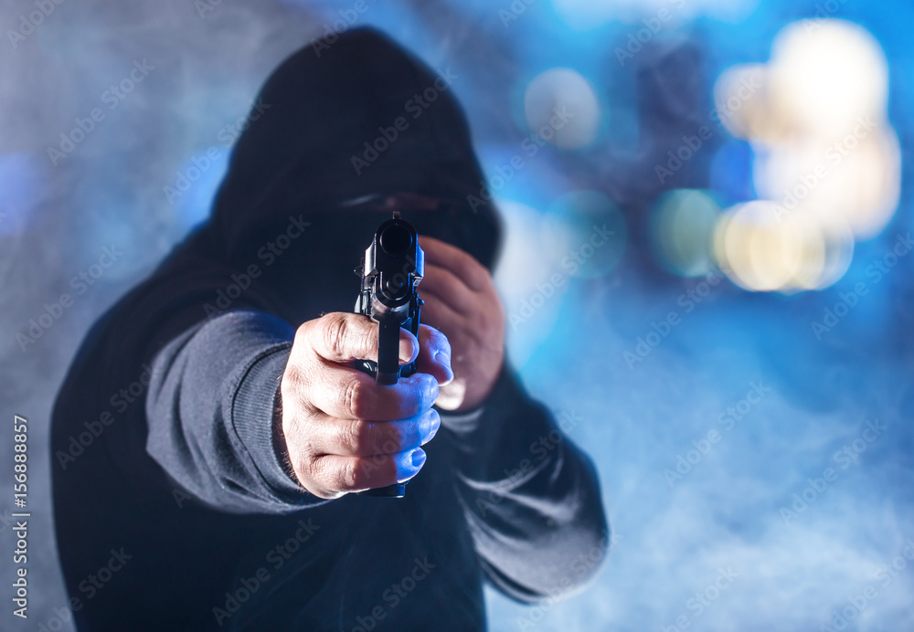 Φωτογραφία nachts droht ein Mann mit einer Schusswaffe