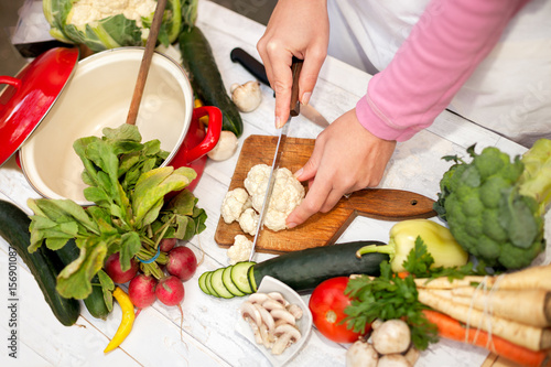 Top view of slicing cauliflower on chopping board