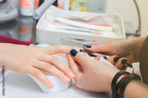 A girl has a manicure in a beauty salon  cleaning the cuticle