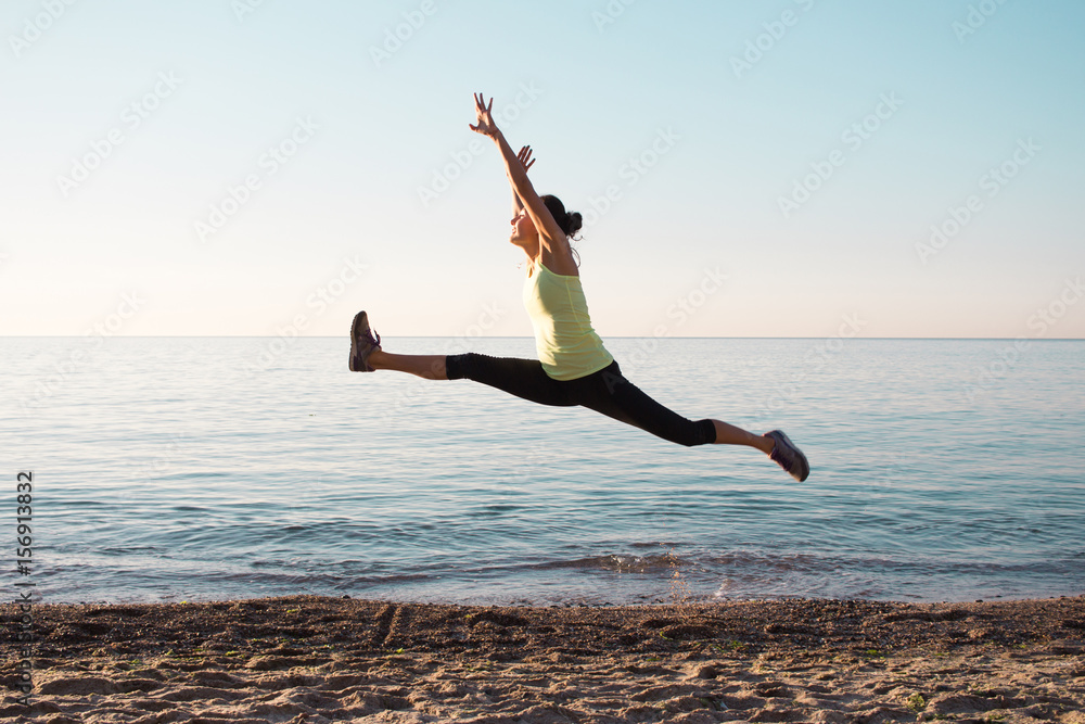 young professional gymnast woman dance on the beach, training exercises with cool junps, sunrise in sea or ocean background young professional gymnast woman dance on the beach, training exercises with cool junps, sunrise in sea or ocean background