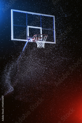 Basketball hoop isolated on black. Basketball arena under rain. Lightened by mixed color lights. © Sergii Chernov