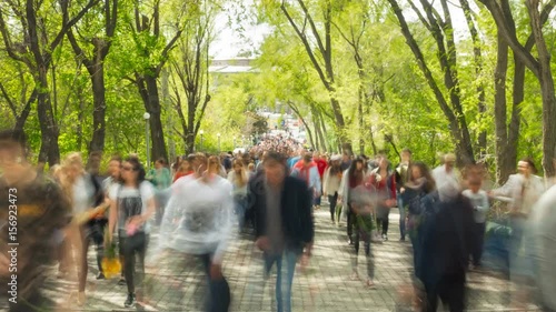 Time lapse of crowd of people walking at you with blurred images on the background of nature
