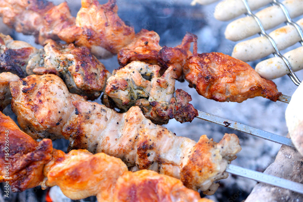 Grilling marinated shashlik on a grill. Shashlik is a form of Shish kebab  popular in Eastern, Central Europe and other places. Shashlyk (meaning  skewered meat) was originally made of lamb. Stock Photo