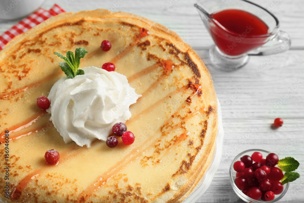 Tasty pancakes with cream and berries on table Tasty pancakes with cream and berries on table