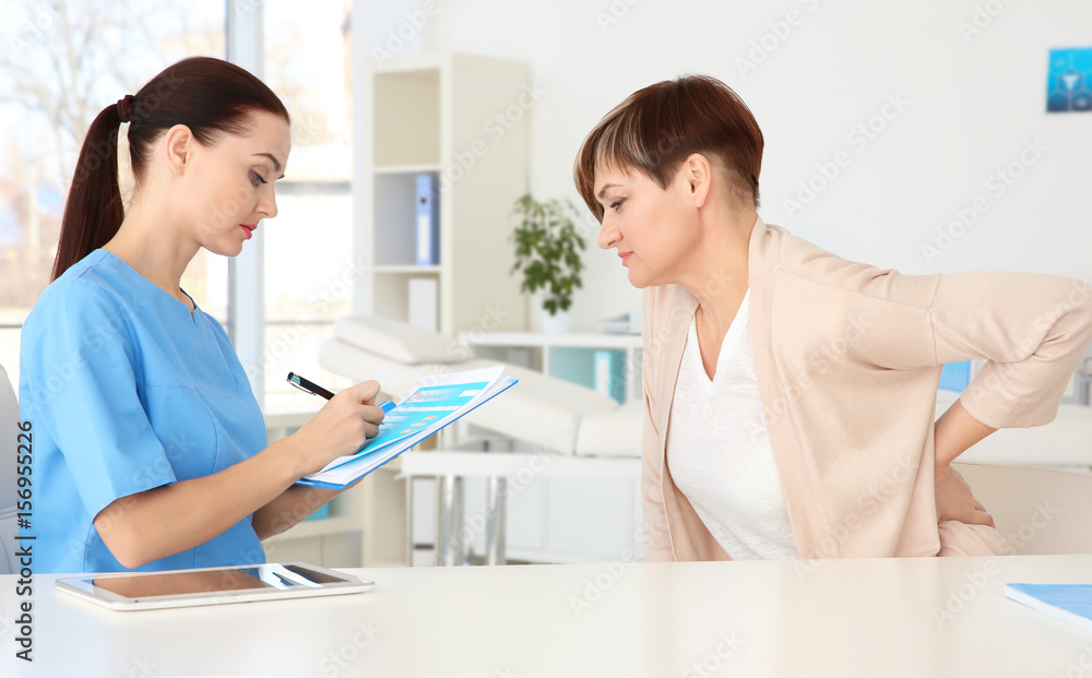Orthopedist examining middle-aged woman in clinic Orthopedist examining middle-aged woman in clinic