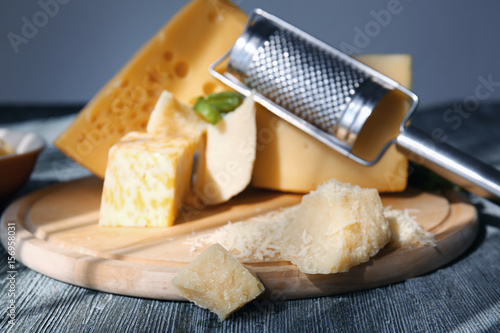 Wooden board with different cheese on table