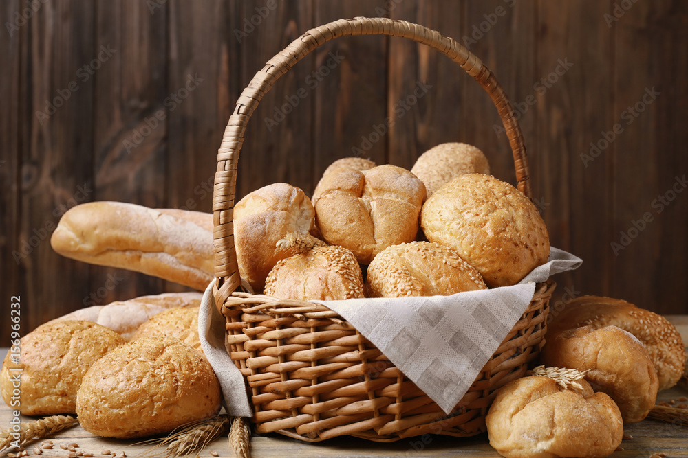 Basket with different bread on wooden background