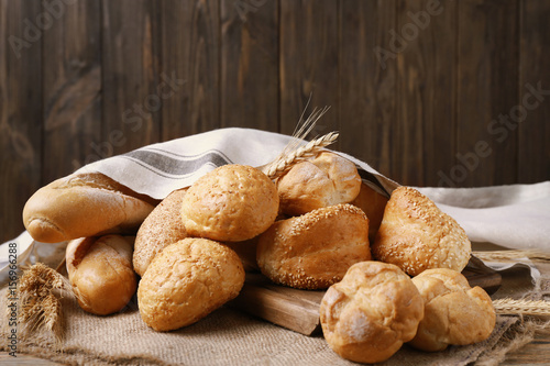 Different bread covered with napkin on wooden background